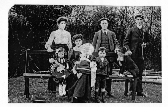 Standing: Alice Annie Allaway (b. 1885), Matthew William Edmund Hughes (b. 22 July 1880 d. 1946), Frederick ?  (Husband of Alice) - Seated: Constance Mary Lily Hughes (b. 4 April 1904 d. 1996), Mary Ann Elizabeth Hughes (nee Allaway b. 15 July 1880 d. Feb 1970), on her lap is Grace Catherine Ann Hughes (b. 4  May 1906 d. 2000), William Matthew Edmund Hughes (b. 1902 d. 1920) – and the dog Carlo who was born the same day as Grace.  - The Bricklayers, Stondon Massey in 1906